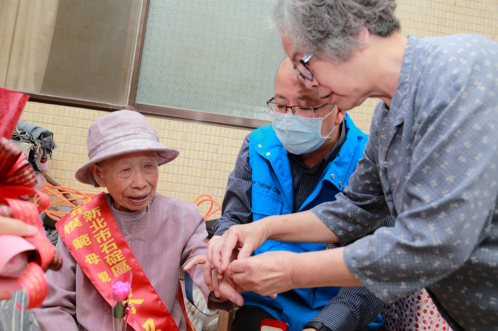 陳招治女士的媳婦幫陳招治（102歲）女士帶上新北巿長侯友宜致贈的戒指